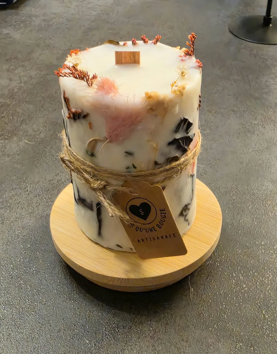 Bougie pilier ornée de fleurs séchées avec son étiquette Plus qu'une bougie